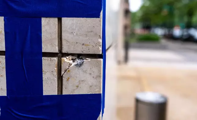 Blue tape is pictured around a possible bullet strike near the shooting scene near the scene of a shooting close to the White House, Sunday, May 24, 2026, in Washington. (AP Photo/Alex Brandon)