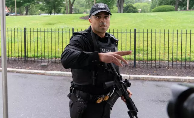 A member of the Secret Service stops journalists from leaving the White House, Saturday, May 23, 2026, in Washington. (AP Photo/Jose Luis Magana)