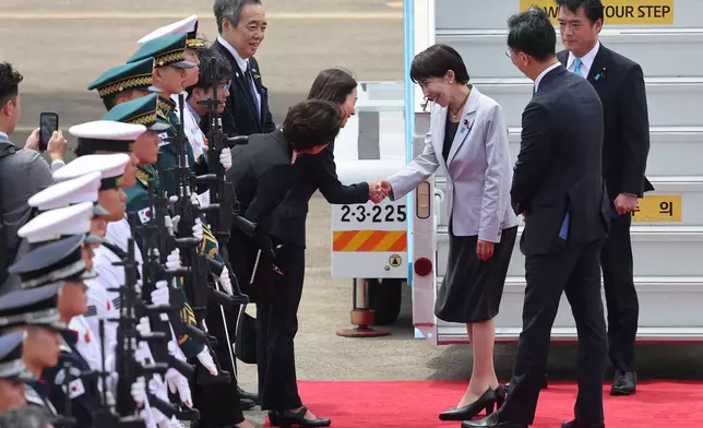 Japan's Prime Minister Sanae Takaichi, third from right, is greeted upon arrival at the Daegu International Airport in Daegu, South Korea, Tuesday, May 19, 2026. (Yoon Kwan-shick/Yonhap via AP)