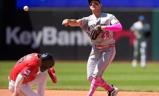 Minnesota Twins shortstop Brooks Lee, right, forces out Cleveland Guardians' Travis Bazzana, left, at second base and completes the throw to first base for the out on Patrick Bailey on a double play ball in the fourth inning of a baseball game in Cleveland, Sunday, May 10, 2026. (AP Photo/Sue Ogrocki)