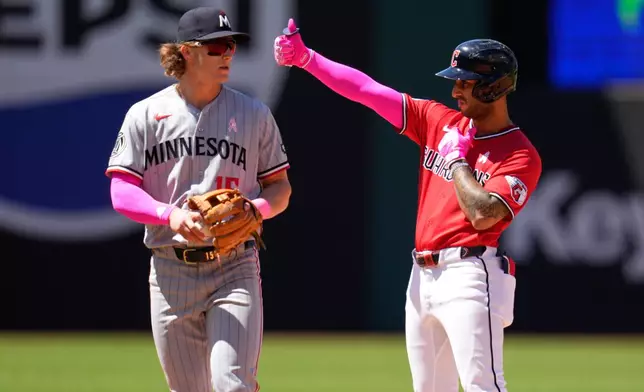 Cleveland Guardians' Brayan Rocchio, right, gestues from second base next to Minnesota Twins second baseman Luke Keaschall, left, after hitting a double in the fourth inning of a baseball game in Cleveland, Sunday, May 10, 2026. (AP Photo/Sue Ogrocki)