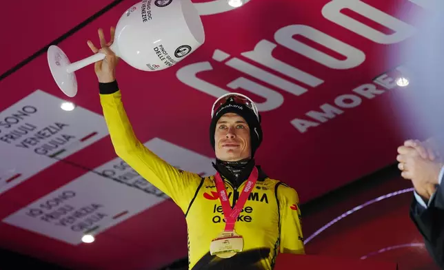 Denmark's Jonas Vingegaard celebrates on the podium after winning the 9th stage of the Giro d'Italia cycling race, from Cervia to Corrno alle Scale, Italy, Sunday May 17, 2026. (Massimo Paolone/LaPresse via AP)