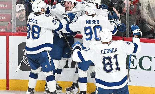 Tampa Bay Lightning's Gage Goncalves, second from left, celebrates with teammates after scoring against the Montreal Canadiens during overtime of Game 6 in the first round of an NHL hockey Stanley Cup playoff series in Montreal, Friday, May 1, 2026. (Graham Hughes/The Canadian Press via AP)