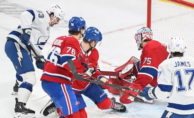Tampa Bay Lightning's Gage Goncalves (93) scores against Montreal Canadiens goaltender Jakub Dobes (75) during overtime of Game 6 in the first round of an NHL hockey Stanley Cup playoff series in Montreal, Friday, May 1, 2026. (Graham Hughes/The Canadian Press via AP)