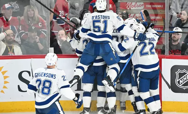 Tampa Bay Lightning players celebrate after a goal by teammate Gage Goncalves (partially obscured) during overtime of Game 6 in the first round of an NHL hockey Stanley Cup playoff series against the Montreal Canadiens in Montreal, Friday, May 1, 2026. (Graham Hughes/The Canadian Press via AP)