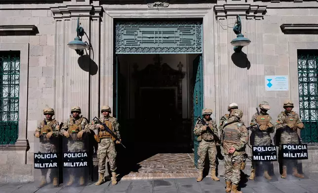 Military police stand outside the government palace while anti-government protests take place in La Paz, Bolivia, Monday, May 18, 2026. (AP Photo/Juan Karita)