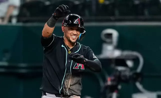 Arizona Diamondbacks' Ildemaro Vargas celebrates his two-run single in the ninth inning of a baseball game against the Texas Rangers Wednesday, May 13, 2026, in Arlington, Texas. (AP Photo/Tony Gutierrez)