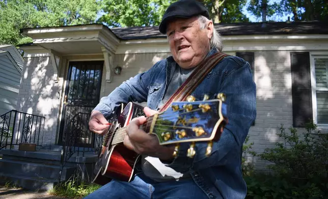 Steve Fowler, a Beale Street musician whose street was bisected by Tennessee's new congressional districts, strums the guitar in his front yard on Thursday, May 7, 2026, in Memphis, Tenn. (AP Photo/Sophie Bates)