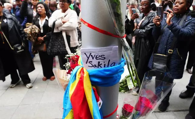 People attend a vigil for Yves Sakila on Henry Street, Dublin, Ireland, Tuesday May 19, 2026. (Brian Lawless/PA via AP)