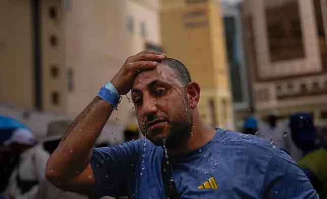A Muslim pilgrim splashes water over his head too cool down outside the Grand Mosque during the annual hajj pilgrimage at the holy city of Mecca, Saudi Arabia, Sunday, May 24, 2026. (AP Photo/Altaf Qadri)