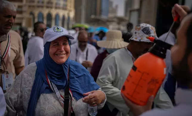 A Muslim pilgrim reacts as a volunteer sprays water to cool them outside the Grand Mosque during the annual hajj pilgrimage at the holy city of Mecca, Saudi Arabia, Sunday, May 24, 2026. (AP Photo/Altaf Qadri)