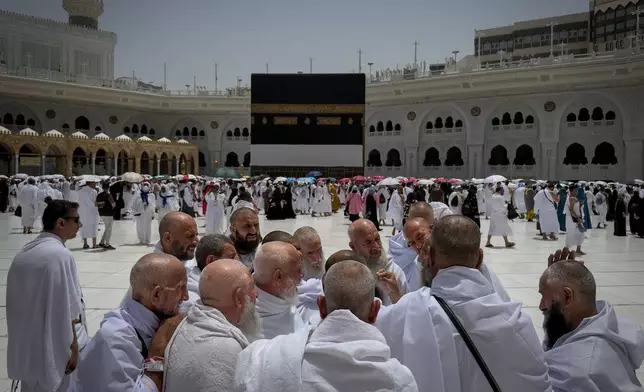 A group of Muslim pilgrims discuss the rituals of circumambulating the Kaaba, Islam's holiest site at the Grand Mosque during the annual Hajj pilgrimage in Mecca, Saudi Arabia, Sunday, May 24, 2026. (AP Photo/Altaf Qadri)