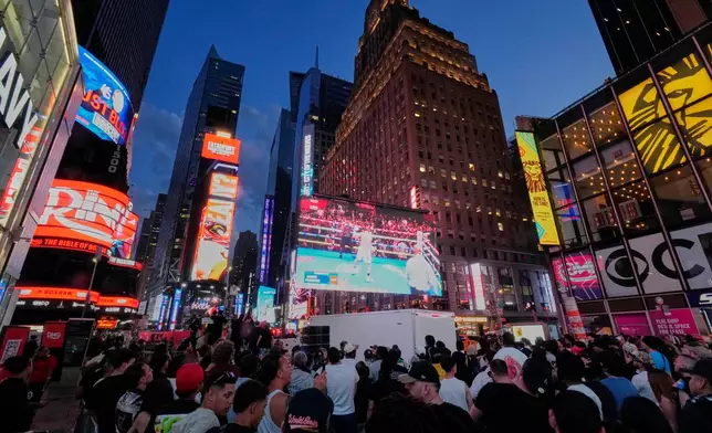 FILE - People gather in Times Square to watch a boxing match, May 2, 2025, in New York. (AP Photo/Frank Franklin II, File)