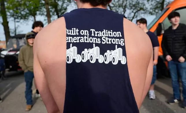 A senior wears a class shirt during Tractor Day for graduating seniors at Airport High School Friday, May 22, 2026, in Carleton, Mich. (AP Photo/Paul Sancya)
