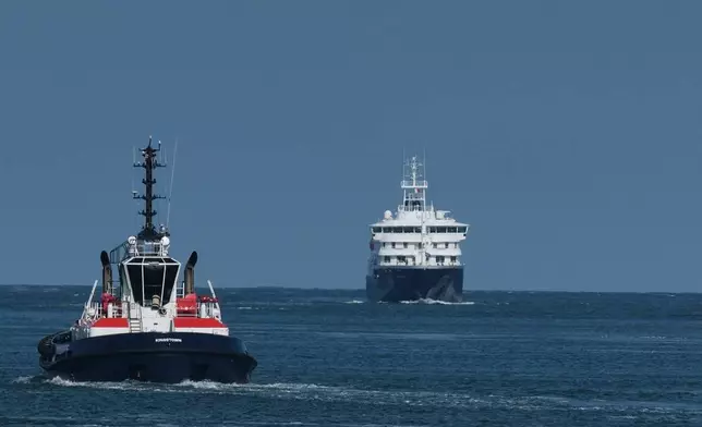 The MV Hondius cruise ship, right, arrives at the Port of Rotterdam, Netherlands, Monday, May 18, 2026. (AP Photo/Patrick Post)