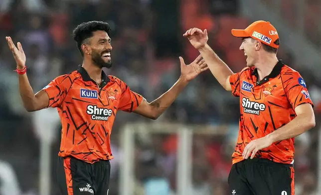 Sunrisers Hyderabad's Praful Hinge, left and Pat Cummins celebrates the wicket of Gujarat Titans' Jos Buttler during the Indian Premier League cricket match between Gujarat Titans and Sunrisers Hyderabad, in Ahmedabad, India, Tuesday, May 12, 2026. (AP Photo/Ajit Solanki)