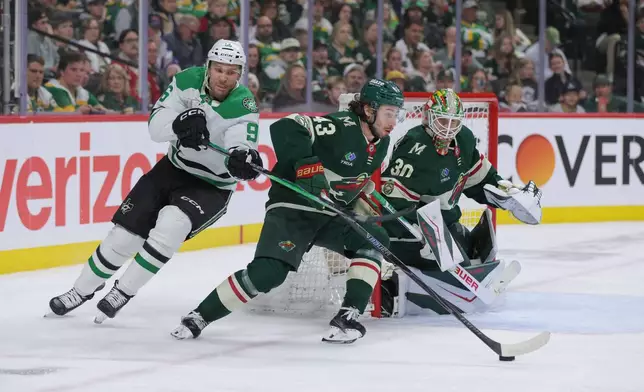 Minnesota Wild defenseman Quinn Hughes (43) skates with the puck in front of goaltender Jesper Wallstedt (30) while Dallas Stars right wing Mikko Rantanen (96) defends during the second period of Game 6 in the first round of the NHL hockey Stanley Cup playoff series Thursday, April 30, 2026, in St. Paul, Minn. (AP Photo/Bailey Hillesheim)