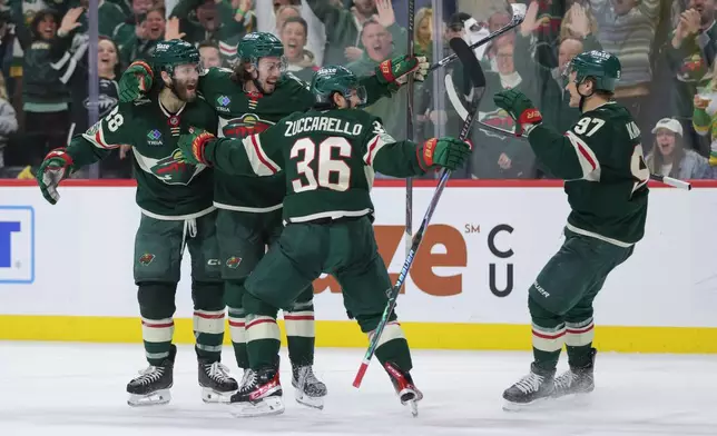 Minnesota Wild defenseman Quinn Hughes, second from the left, celebrates with teammates after scoring during the third period of Game 6 in the first round of the NHL hockey Stanley Cup playoff series against the Dallas Stars, Thursday, April 30, 2026, in St. Paul, Minn. (AP Photo/Bailey Hillesheim)