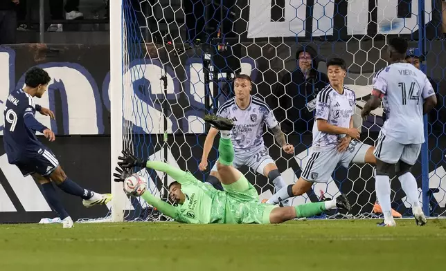 San Jose Earthquakes goalkeeper Daniel de Sousa Britto, bottom, defends a shot by Vancouver Whitecaps midfielder Jeevan Badwal, left, during the second half of an MLS soccer match Saturday, May 9, 2026, in San Jose, Calif. (AP Photo/Jeff Chiu)