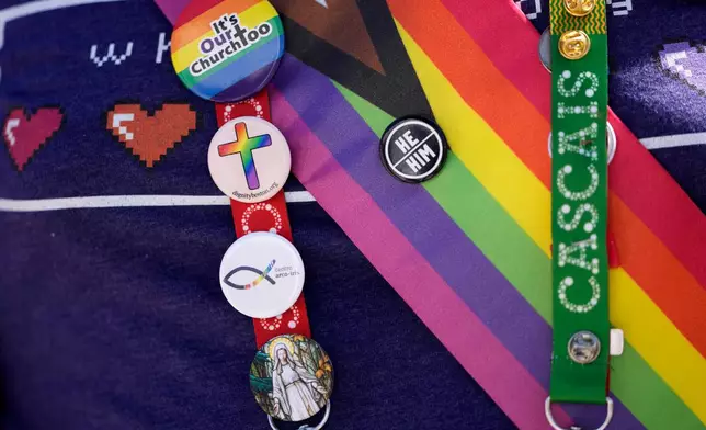 FILE - A representative of Dignity USA, a group of LGBTQ+ Catholics, wears pins on the lanyard of his pilgrim credential, outside the Sao Vicente de Paulo Parish Social Center after Pope Francis visited the center in the Serafina neighbourhood of Lisbon, Aug. 4, 2023. (AP Photo/Armando Franca, File)