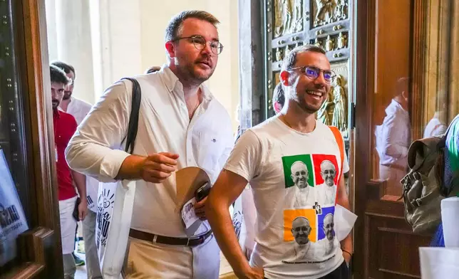 FILE - Members of the LGBTQ+ Catholics and their families who joined a Holy Year pilgrimage to Rome walk through the Holy Door of St. Peter's Basilica at the Vatican, Saturday, Sept. 6, 2025. (AP Photo/Andrew Medichini, File)