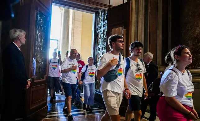 FILE - Members of the LGBTQ+ Catholics and their families who joined a Holy Year pilgrimage to Rome walk through the Holy Door of St. Peter's Basilica at the Vatican, Saturday, Sept. 6, 2025. (AP Photo/Andrew Medichini, File)