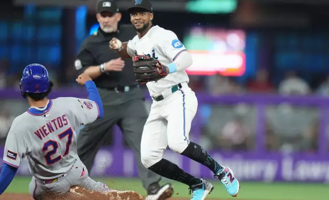 New York Mets' Mark Vientos (27) is out at second as Miami Marlins second baseman Xavier Edwards, right, throws to first for a double play during the second inning of a baseball game, Saturday, May 23, 2026, in Miami. (AP Photo/Lynne Sladky)