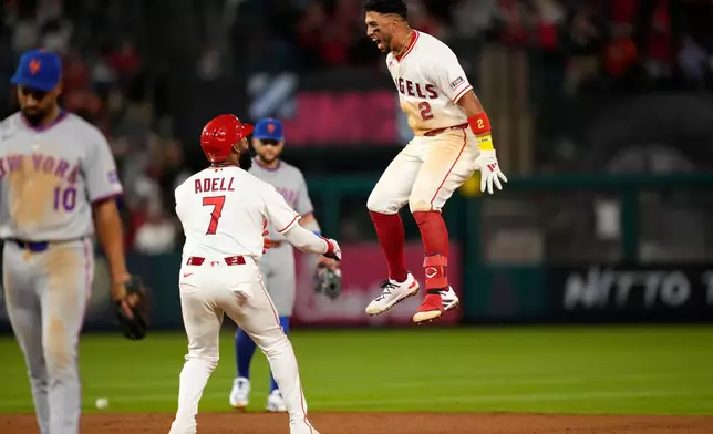 Los Angeles Angels' Oswald Peraza, right, celebrates his walk off single with Jo Adell, center, as New York Mets second baseman Marcus Semien walks off the field in the 10th inning of a baseball game Saturday, May 2, 2026, in Anaheim, Calif. (AP Photo/Mark J. Terrill)
