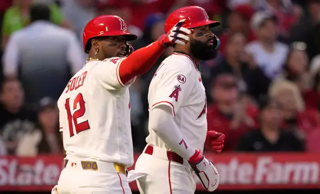 Los Angeles Angels' Jorge Soler, left, gestures toward Vaughn Grissom after Grissom hit an RBI single that scored Soler and Jo Adell, right, during the fourth inning of a baseball game Saturday, May 2, 2026, in Anaheim, Calif. (AP Photo/Mark J. Terrill)