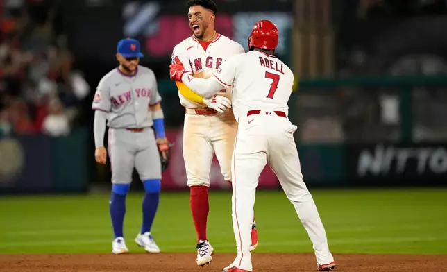 Los Angeles Angels' Oswald Peraza, center, celebrates his walk off single with Jo Adell, right, as New York Mets' Bo Bichette walks off the field in the 10th inning of a baseball game Saturday, May 2, 2026, in Anaheim, Calif. (AP Photo/Mark J. Terrill)