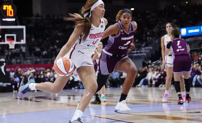Washington Mystics' Shakira Austin (0) drives past Toronto Tempo's Nyara Sabally (8) during first-half WNBA basketball game action in Toronto, Friday, May 8, 2026. (Nathan Denette/The Canadian Press via AP)