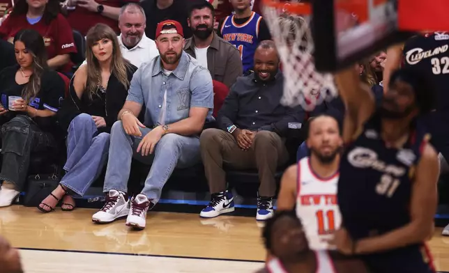 Taylor Swift and Travis Kelce watch the first half of Game 3 in the Eastern Conference finals NBA basketball playoffs series between the New York Knicks and the Cleveland Cavaliers in Cleveland, Saturday, May 23, 2026. (AP Photo/Tim Phillis)