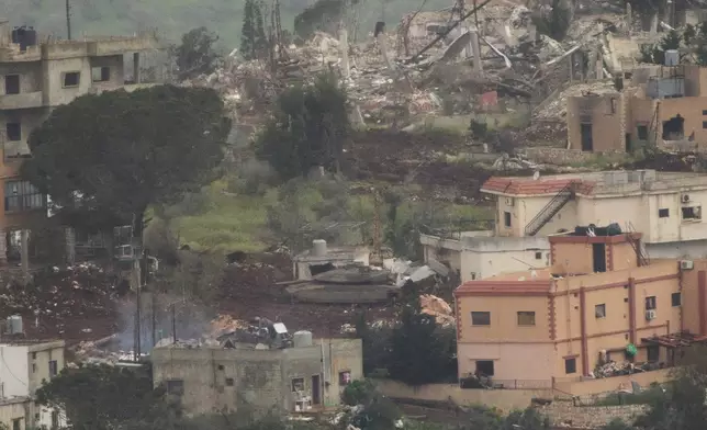 Israeli soldiers drive a tank inside a village in southern Lebanon, as seen from northern Israel, Tuesday, May 5, 2026. (AP Photo/Ariel Schalit)