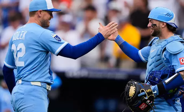 Kansas City Royals starting pitcher Stephen Kolek (32) celebrates with catcher Carter Jensen after throwing a complete game shutout baseball game against the Seattle Mariners, Saturday, May 23, 2026, in Kansas City, Mo. (AP Photo/Charlie Riedel)