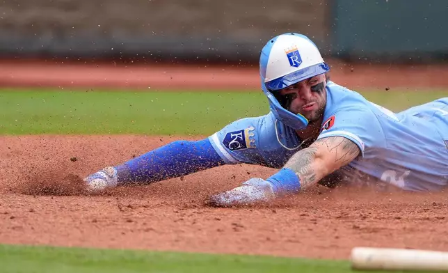 Kansas City Royals' Carter Jensen slides home to score on a single by Isaac Collins during the sixth inning of a baseball game against the Seattle Mariners, Saturday, May 23, 2026, in Kansas City, Mo. (AP Photo/Charlie Riedel)