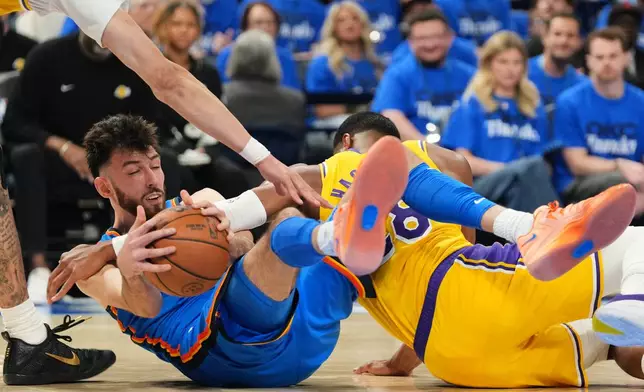 Oklahoma City Thunder's Chet Holmgren, left, competes for a loose ball against Los Angeles Lakers' Jaxson Hayes, left, and Rui Hachimura, right, in the second half of Game 1 in a second-round NBA basketball playoffs series Tuesday, May 5, 2026 in Oklahoma City. (AP Photo/Kyle Phillips)