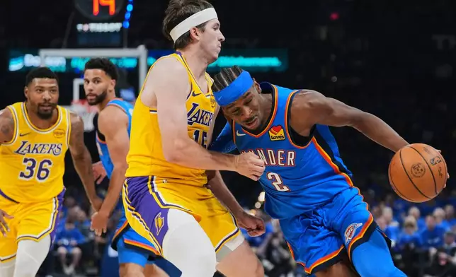 Oklahoma City Thunder guard Shai Gilgeous-Alexander (2) drives to the basket as Los Angeles Lakers' Austin Reaves, left, defends in the second half of Game 1 in a second-round NBA basketball playoffs series Tuesday, May 5, 2026 in Oklahoma City. (AP Photo/Kyle Phillips)