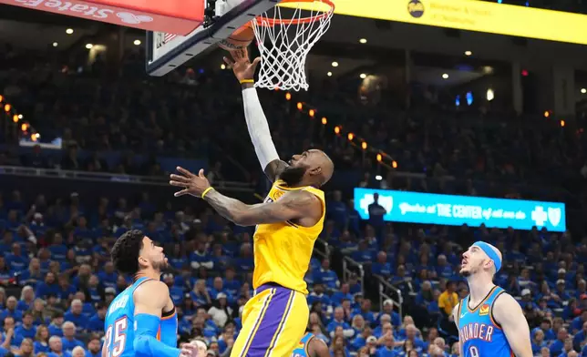 Los Angeles Lakers forward LeBron James shoots between Oklahoma City Thunder's Ajay Mitchell (25) and Alex Caruso (9) in the first half of Game 1 in a second-round NBA basketball playoffs series Tuesday, May 5, 2026 in Oklahoma City. (AP Photo/Kyle Phillips)