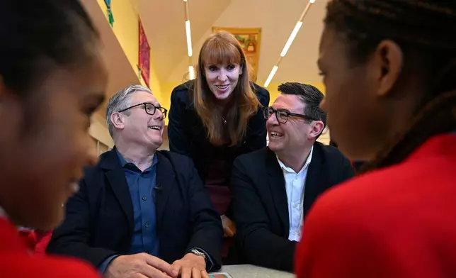 FILE - Britain's Prime Minister Keir Starmer, left, former deputy prime minister Angela Rayner and Manchester Mayor Andy Burnham meet with school children at a primary school in Ashton-under-Lyne, north-west England, Monday April 13, 2026. (Paul Ellis/Pool Photo via AP, File)