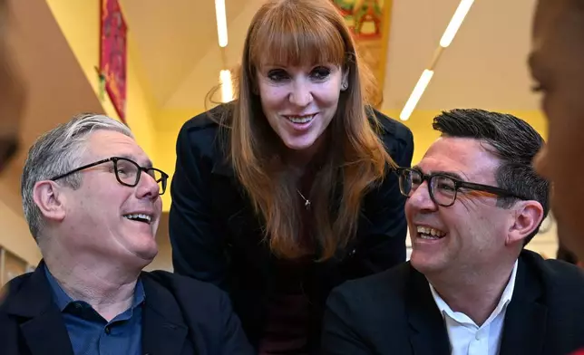 FILE - Britain's Prime Minister Keir Starmer, left, former deputy prime minister Angela Rayner and Manchester Mayor Andy Burnham meet with school children at a primary school in Ashton-under-Lyne, north-west England, Monday April 13, 2026. (Paul Ellis/Pool Photo via AP, File)