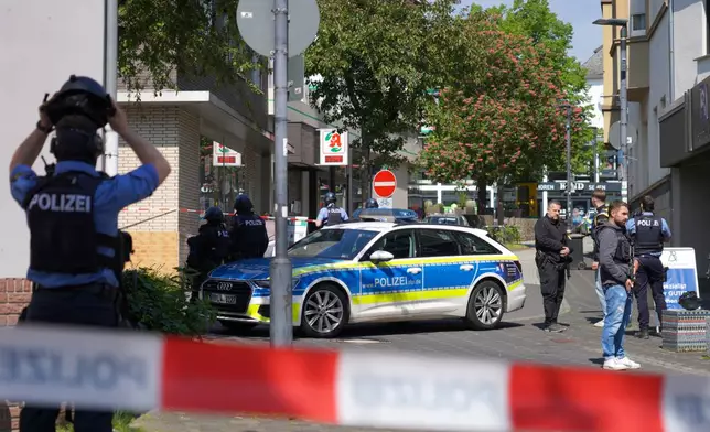 Police officers stand at the scene of a hostage-taking at a bank branch in Sinzig, Germany, Friday, May 8, 2026. (Sascha Ditscher/dpa via AP)