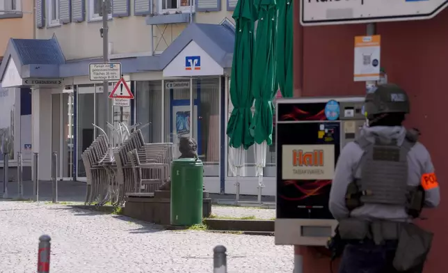 A police officers stands at the scene of an incident where, according to reports, a hostage situation has occurred at a bank branch in Sinzig, Germany, Friday, May 8, 2026. (Thomas Frey/dpa via AP)