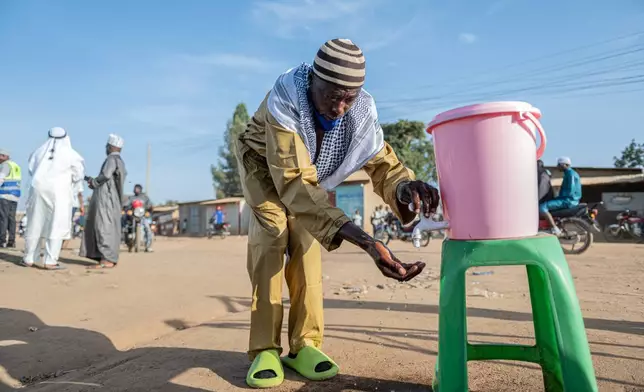 A Muslim washes his hands as a precaution against Ebola before attending the Eid al-Adha prayers at Sayo Muhamed School in Bunia, Congo, Wednesday, May 27, 2026. (AP Photo/Moses Sawasawa)