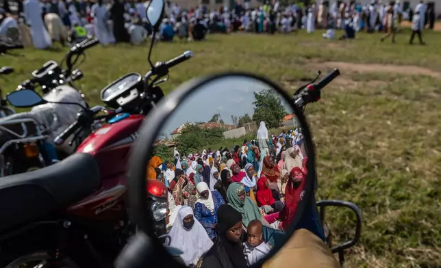 Muslims are reflected in a motorcycle mirror as they gather to pray at Sayo Muhamed School during the Eid al-Adha celebration amid an Ebola outbreak in Bunia, Congo, Wednesday, May 27, 2026. (AP Photo/Moses Sawasawa)