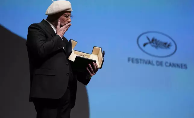 John Travolta holds his honorary Palme d'Or during the 79th international film festival, Cannes, southern France, Friday, May 15, 2026. (Photo by Scott A Garfitt/Invision/AP)