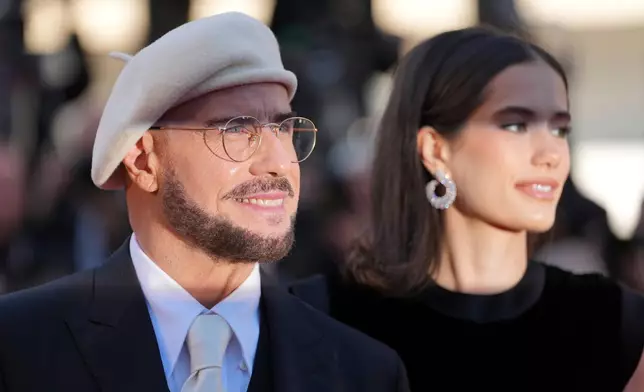 John Travolta, left, and Ella Bleu Travolta pose for photographers upon arrival at the premiere of the film 'Karma' at the 79th international film festival, Cannes, southern France, Friday, May 15, 2026. (AP Photo/Andreea Alexandru)