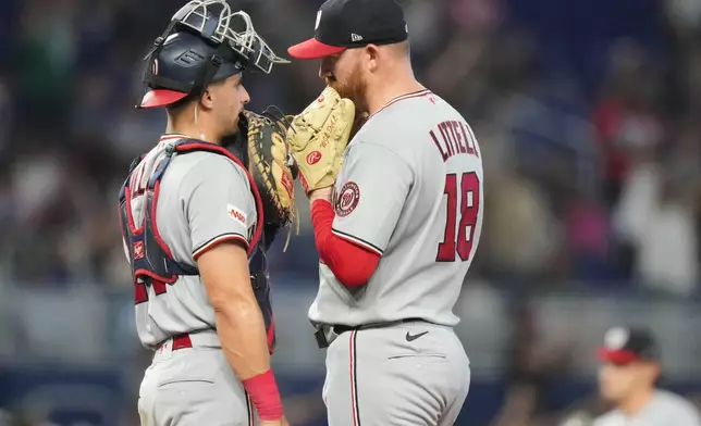 Washington Nationals pitcher Zack Littell (18) talks with catcher Drew Millas, left, during the fourth inning of a baseball game against the Miami Marlins, Saturday, May 9, 2026, in Miami. (AP Photo/Lynne Sladky)