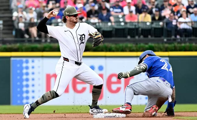 Detroit Tigers second baseman Zach McKinstry, left, throws to first base after forcing out Toronto Blue Jays' Yohendrick Pinango at second base during the first inning of a baseball game, Saturday, May 16, 2026, in Detroit. (AP Photo/Jose Juarez)