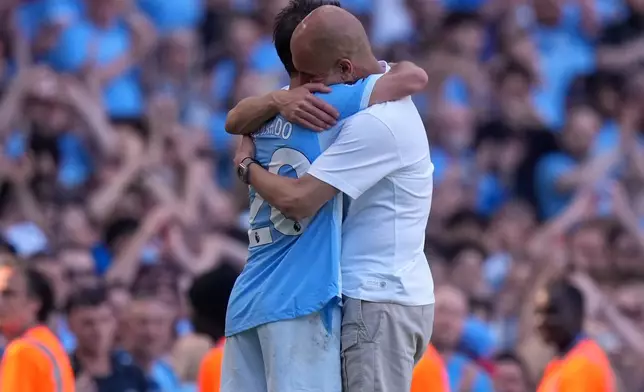 Manchester City's head coach Pep Guardiola hugs Manchester City's Bernardo Silva as he played last match for the team during a Premier League soccer match between Manchester City and Aston Villa in Manchester, England, Sunday, May 24, 2026. (AP Photo/Alastair Grant)