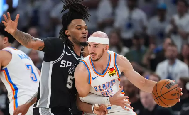 Oklahoma City Thunder guard Alex Caruso (9) moves against San Antonio Spurs guard Stephon Castle (5) in the second half of Game 5 in the Western Conference finals NBA basketball playoffs series, Tuesday, May 26, 2026, in Oklahoma City. (AP Photo/Julio Cortez)